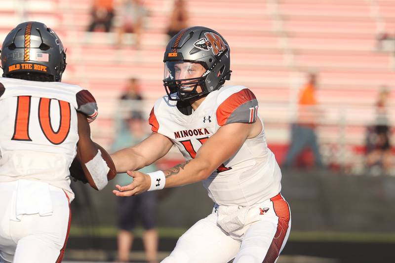 Minooka’s Gavin Dooley hands the ball off against Bolingbrook. Friday, Aug. 26, 2022, in Bolingbrook.