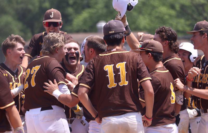 Jacobs’ Jack Celler is greeted by the Golden Eagles after his home run against Hononegah in Class 4A Sectional baseball action at Carpentersville Saturday.