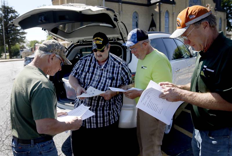 U.S. Army veteran Dan Klapperich, (second from left) who served in the Vietnam War, explains the flag placing operation to volunteers Jim Gerlick, Steve Huff and Jack Warneke on Friday, May 26, 2023, at St. John the Baptist Cemetery, in Johnsburg.