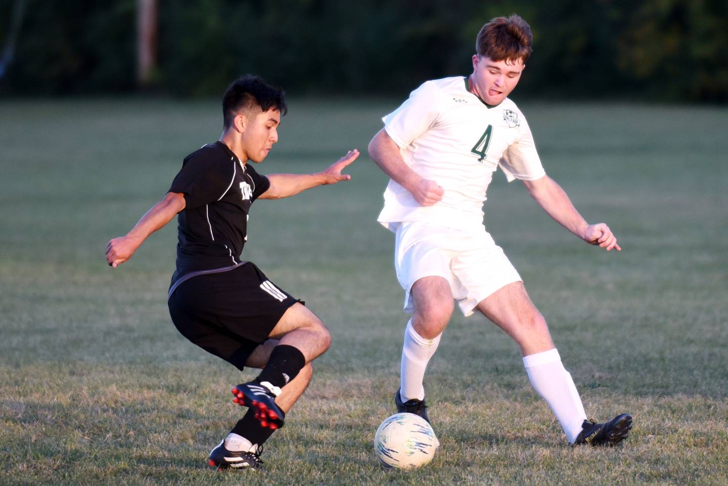 Trinity's Akira Hori, left, looks to dribble past Grant Park's Aiden Overbeek during a game at Trinity Thursday, Oct. 9, 2025.