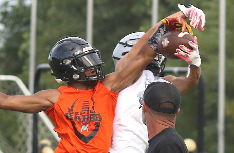 Ethan McCarter tries to break up an interception by a Kaneland player during a 7-on-7 Tuesday, July 26, 2022, at Kaneland High School in Maple Park.