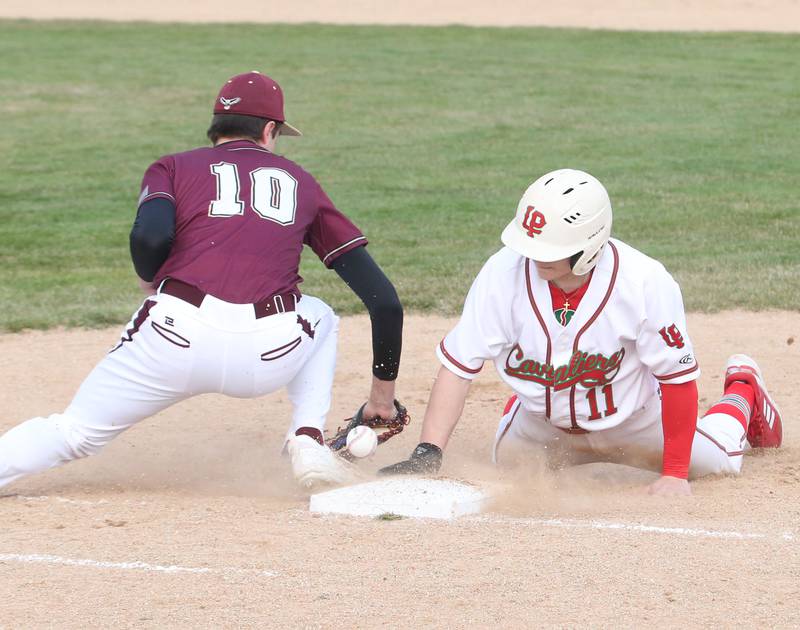 L-P's Adrian Arzola dives back into first base as the ball gets away from Dunlap's Ryan DiGiallonardo on Thursday, March 30, 2023 at Dickinson Field in Oglesby.