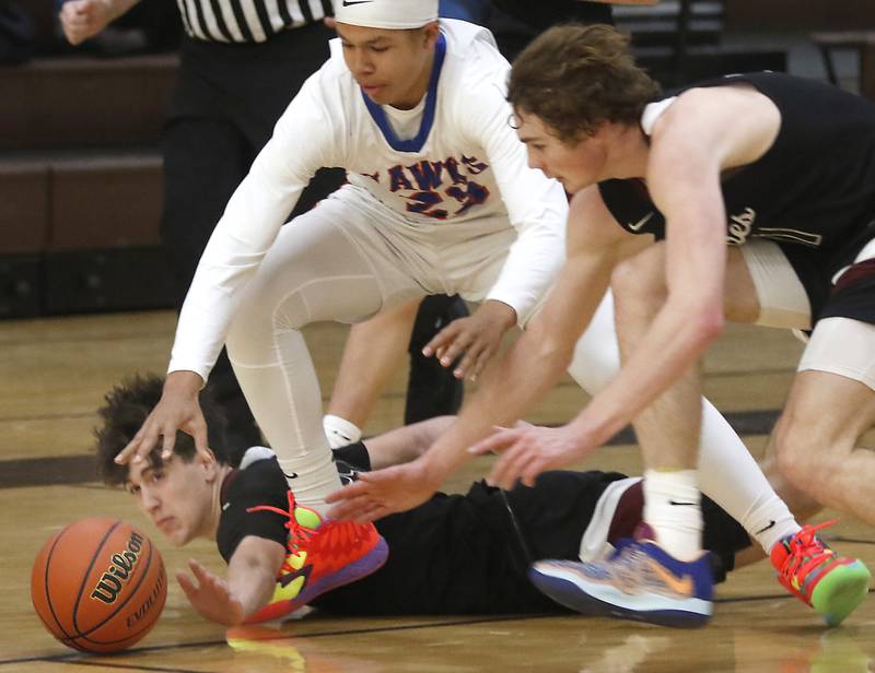 Prairie Ridge's Ben Gablenz dives after a loose ball as Hoffman Estates’ Nate Cleveland and Prairie Ridge's James Muse also chase the ball during a Hinkle Holiday Classic basketball game Wednesday, Dec. 28, 2022, at Jacobs High School in Algonquin.