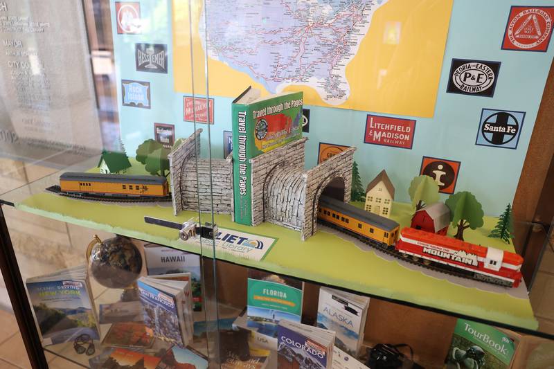 Guest are greeted by Jan Stack’s had crafted display of a train traveling through a book at the Joliet Public Library Black Road Branch for their Travel Through the Pages summer reading program on Thursday May 30, 2024 in Joliet.