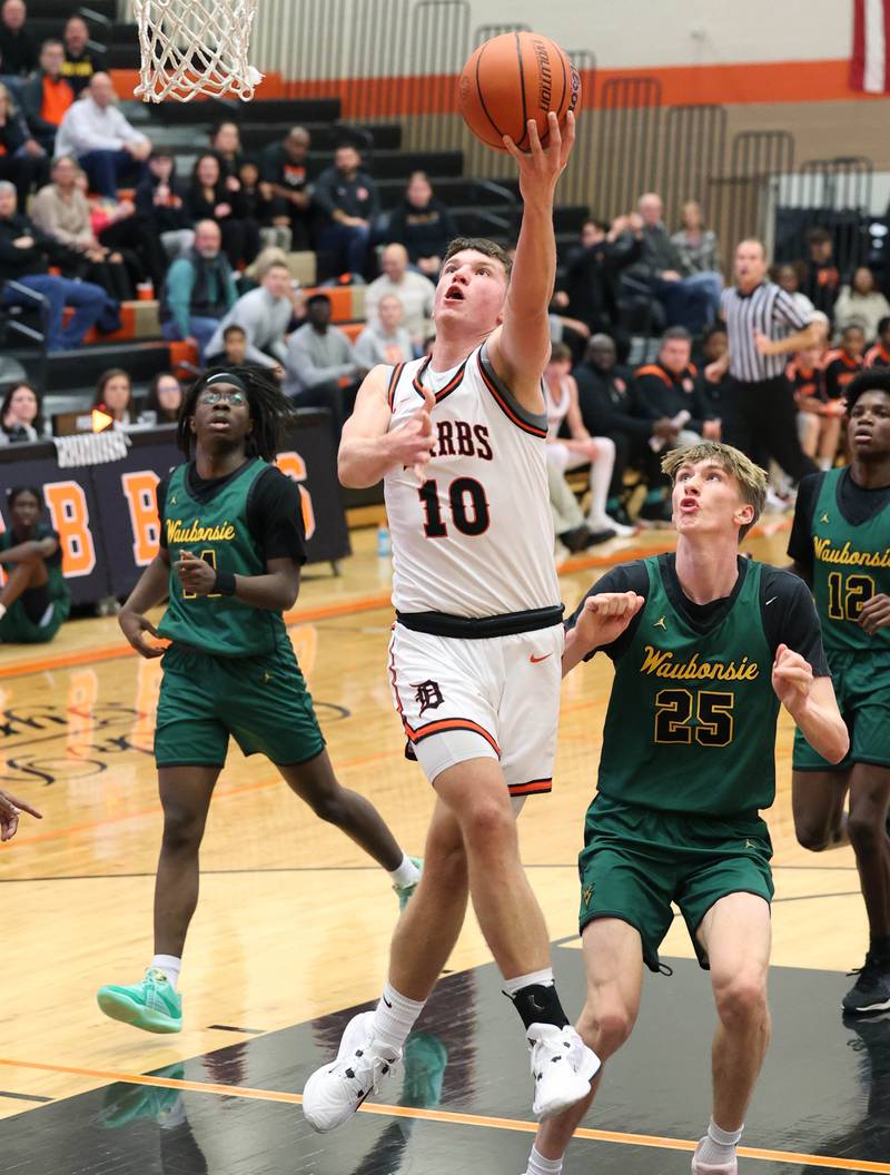 DeKalb’s Eric Rosenow drives through the Waubonsie Valley defense for a basket during their game Friday, Dec. 15, 2023, at DeKalb High School.