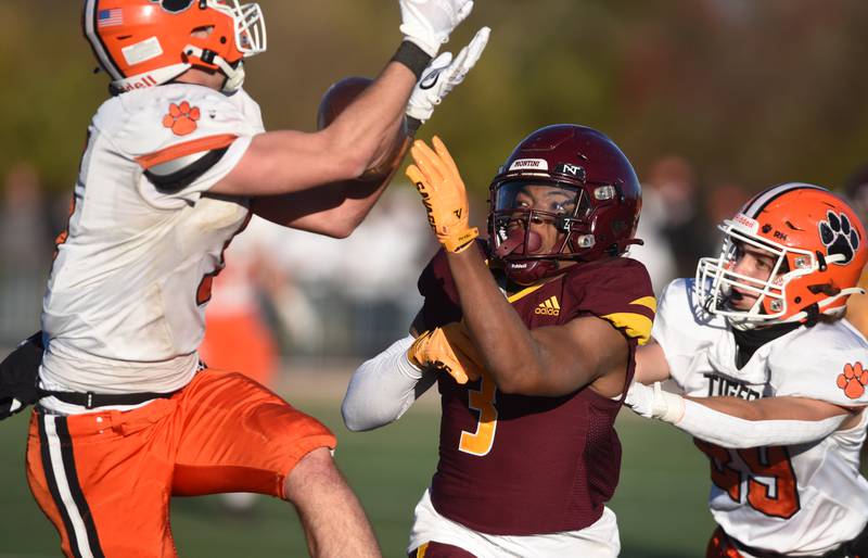 Joe Lewnard/jlewnard@dailyherald.com
A pass to Montini's Josiah James, middle, is broken up by Byron's Ashton Henkel, left, as the Tigers’ Byron’s Kye Aken helps with coverage during the Class 3A semifinal game in Lombard Saturday.