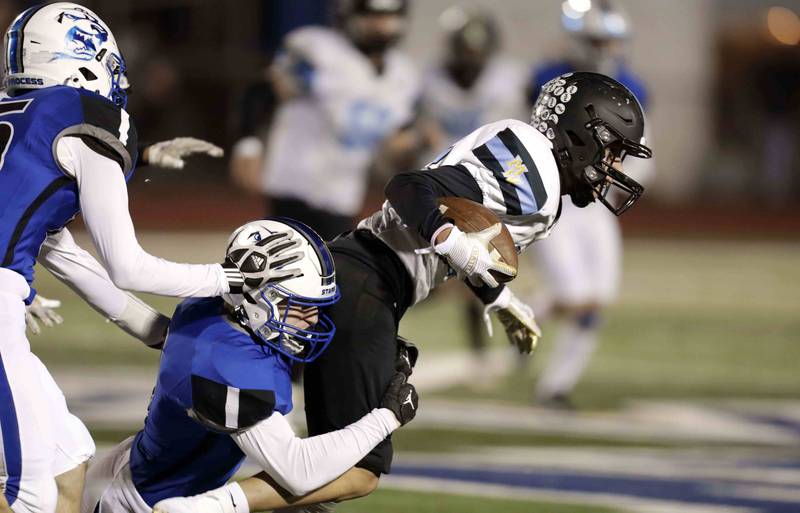 Maine West’s Gabriel Moreno (87) tries for a few more yards Friday October 28, 2022 in St. Charles.