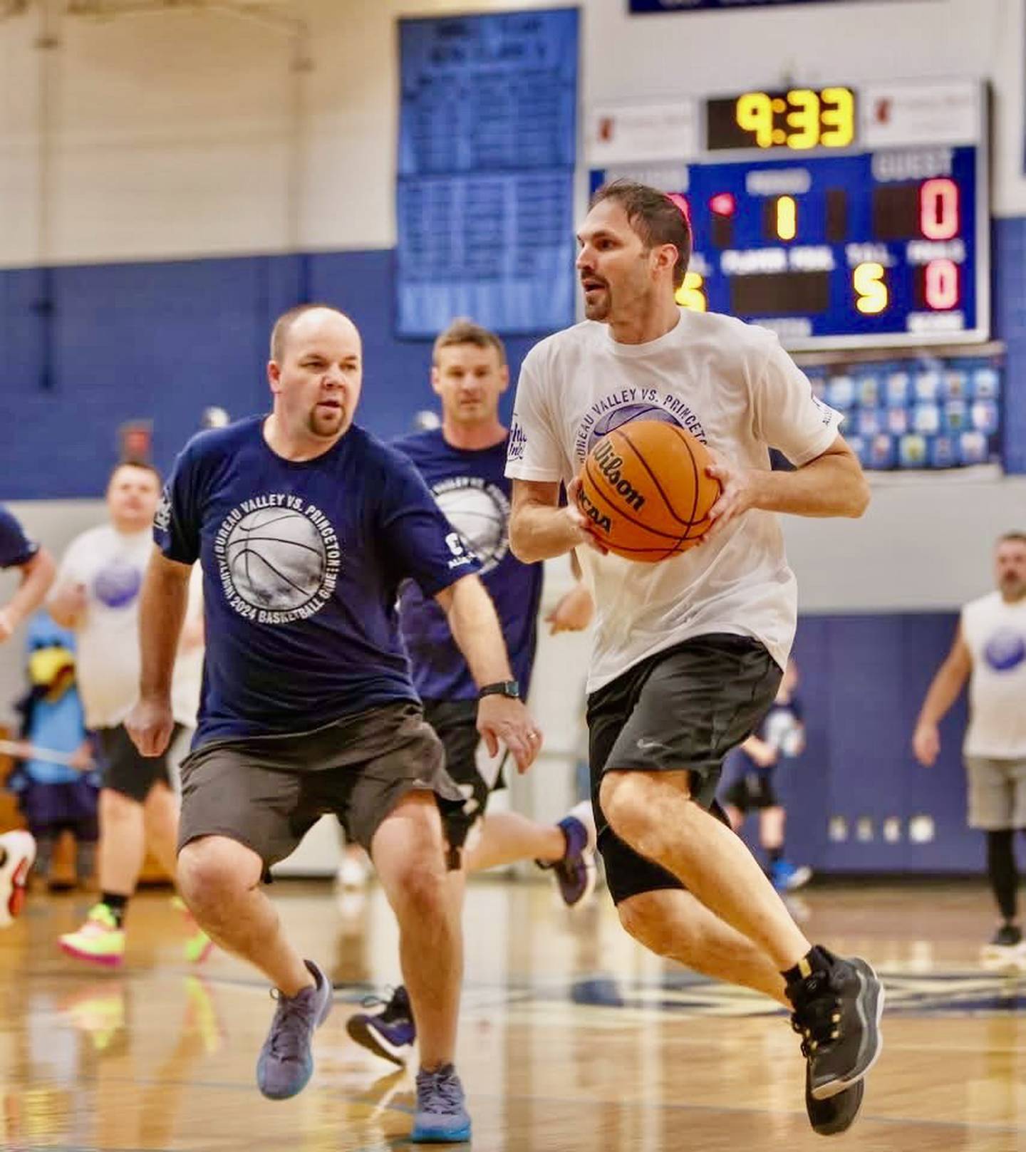 Former Tiger standout Scott DeVore (2002) drives on Bureau Valley coach and alum Jason Marquis (2004) during Sunday's Alumni Game at the Storm Cellar.