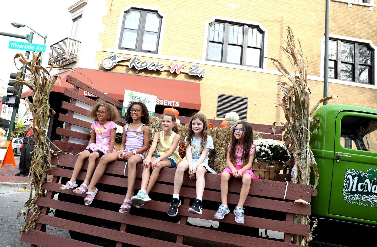 (Right to left) Mariana Okpala, 6, Cecilia Okpala, 8, Ashley Funk, 8, Avery Reilly, 8 and Melanie Funk, 6, pose for a photo along Riverside Avenue on Friday, Oct. 11, 2024 during Scarecrow Weekend in downtown St. Charles.
