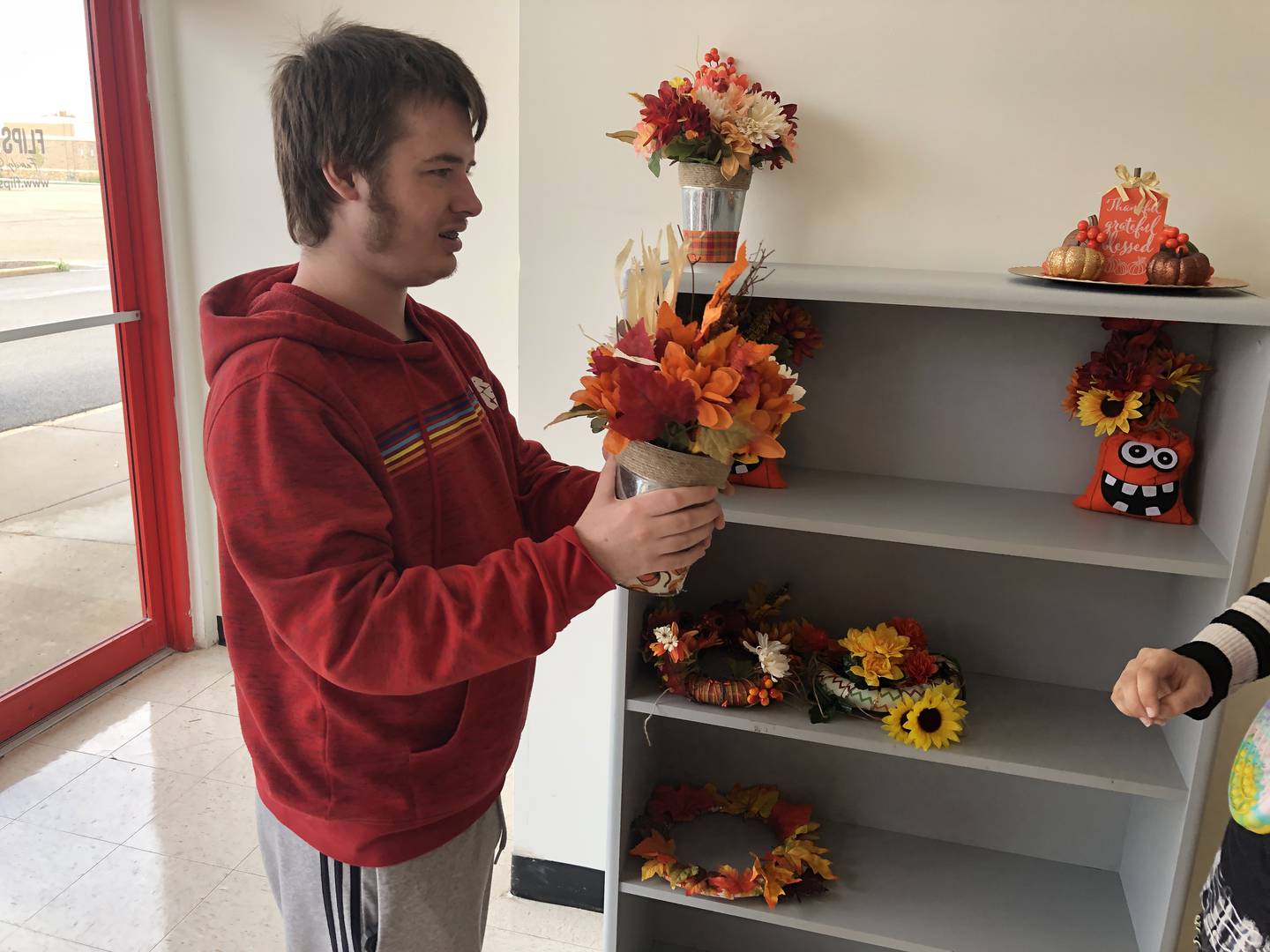 Brandan Komers helped shelve the home decor items he and others made on Monday, Sept.25, 2023, at Across the Bridge, McHenry. The store offers clients of the McHenry Community High School District 156 BRIDGES program the opportunity to learn how to work in a retail environment.
