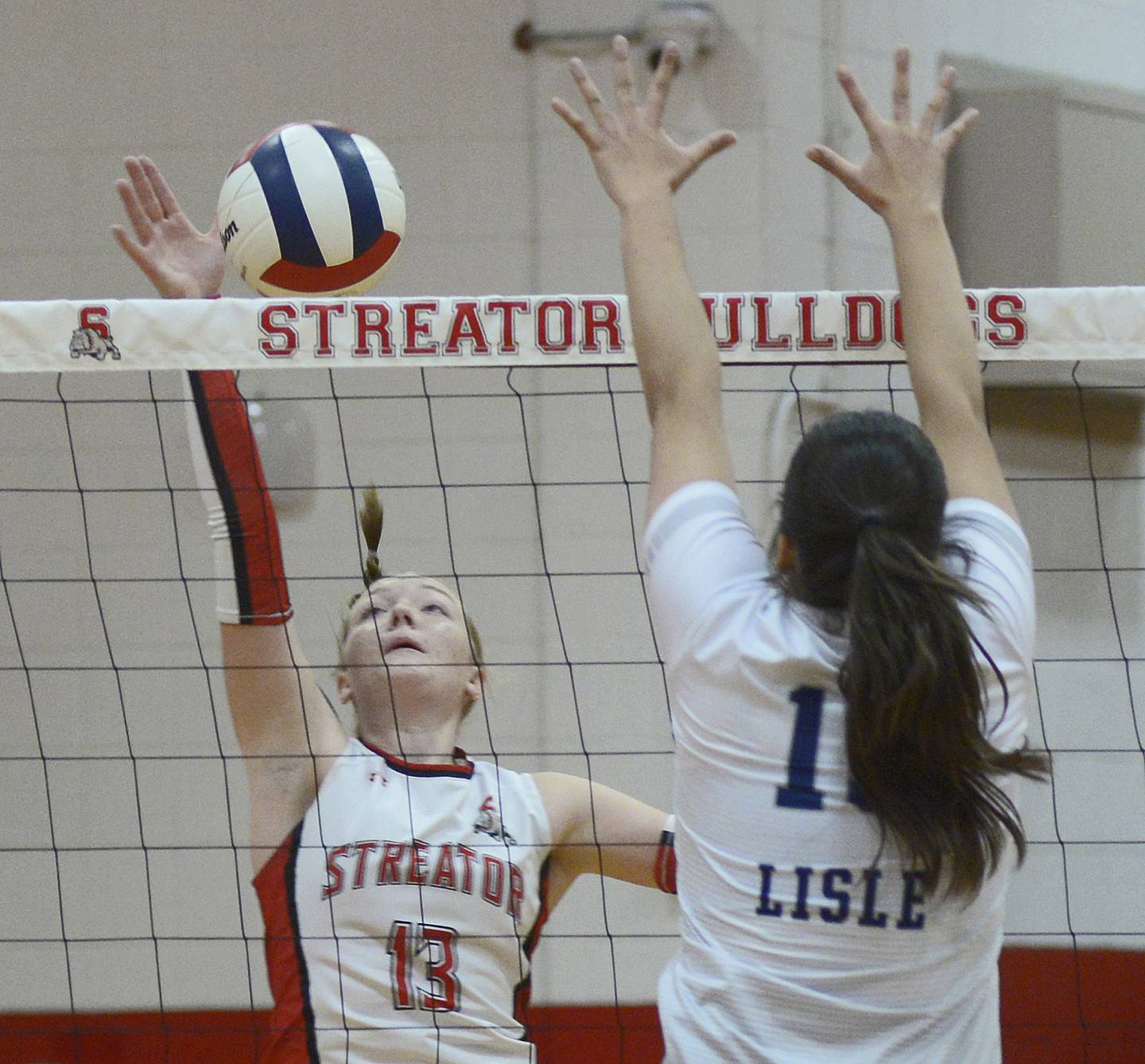 Streator’s  Kindle Sweeden prepares a spike as Lisle’s Sophia Harer sets to block  in the 1st set Tuesday during match at Streator.