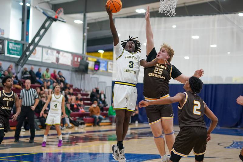 Yorkville Christian's Jayden Riley (3) drives to the basket against Joliet Catholic's Michael Lynch (25) during a basketball game at Yorkville Christian High School on Monday, January 13, 2025.