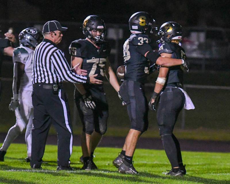 Sycamore Miles Galindo, right, gets a hug from teammate Sycamore Joseph Culotta (33) after Miles scores a touchdown in the second quarter while taking on Evergreen Park in the first week of play offs on Friday Oct. 27, 2023, held at Sycamore High School.