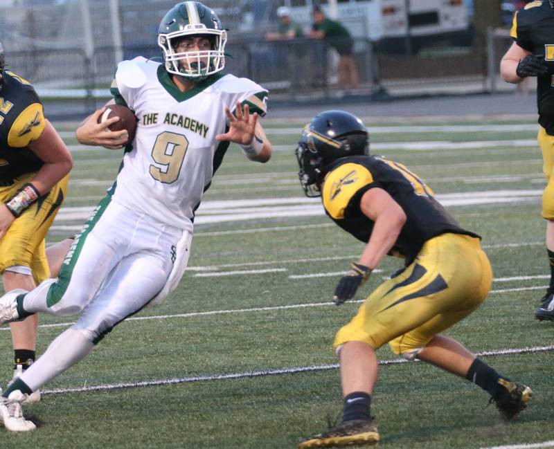 St. Bede quarterback Max Bray gains a few yards as he is met by Tuscola's Austin Cummings on Friday, Aug. 25, 2023 at Tucci Stadium  in Bloomington.