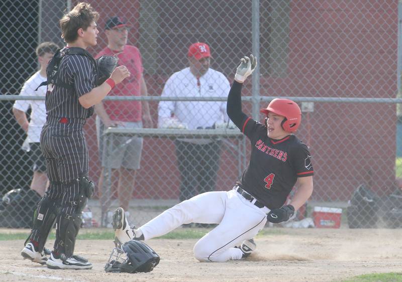 Erie-Prophetstown's Parker Rangel slides into home to score a run as Hall catcher Greyson Bickett waits for the late throw on Monday, April 28, 2025 in Foley Field at Kirby Park in Spring Valley.