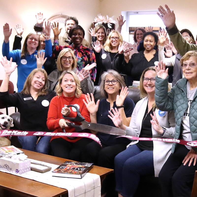 Tara Russo, executive director of Elder Care Services, cuts the ribbon Wednesday, Nov. 20, 2024, with other members of the staff and attendees at Elder Care Services’ new Cozy Corner in their facility at 1701 East Lincoln Highway in DeKalb. Cozy Corner offers seniors a community space for socializing, learning and activities.