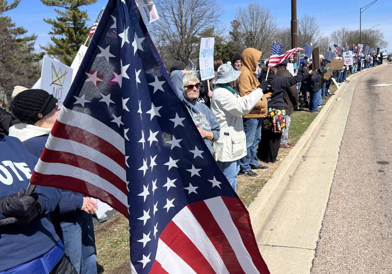 Protesters line Sycamore Road in DeKalb Saturday, March 28, 2026, during a No Kings march and rally against the federal actions of President Donald Trump and his administration.