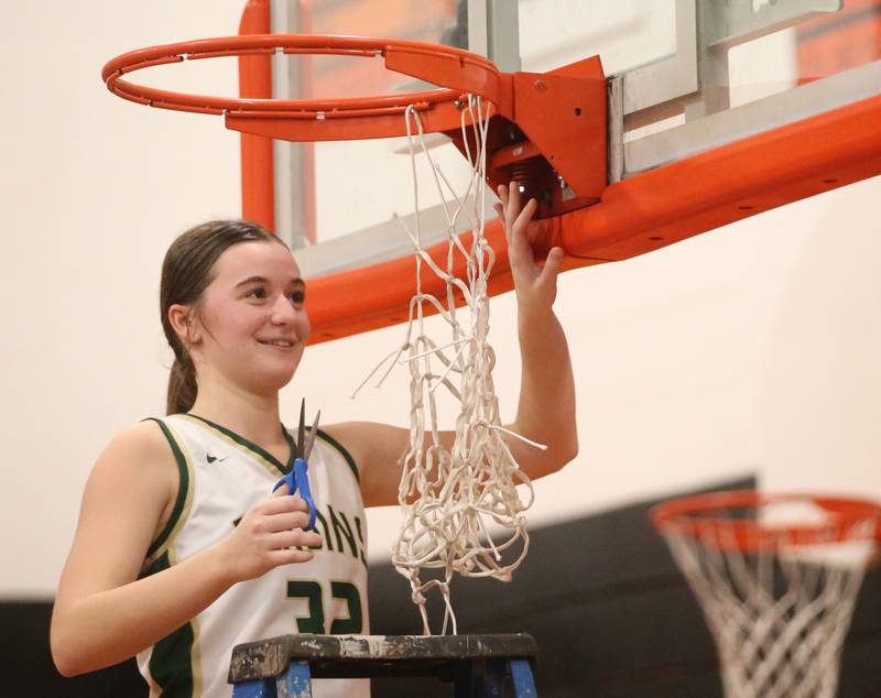 St. Bede's Quinn McClain smiles while cutting down a piece of the net after defeating Serena in the Class 1A Sectional final game on Thursday, Feb. 22, 2024 at Gardner-South Wilmington High School.