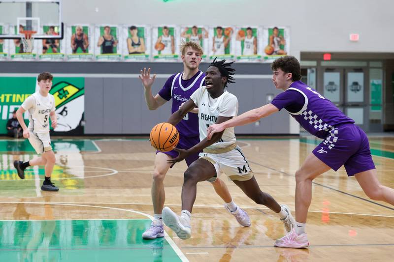 Bishop McNamara's Corey Hathaway maneuvers through Wilmington's Ryker Feil, left, and Declan Moran during Bishop McNamara's 61-24 victory over Wilmington in the IHSA Class 2A Seneca Sectional semifinal on Tuesday, March 3, 2026.