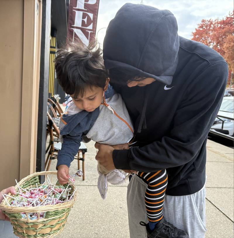 Zael Arellano, 2, of Woodstock, is held by his father Jordan Arellano during Halloween on the Square in Woodstock Oct. 31, 2025.