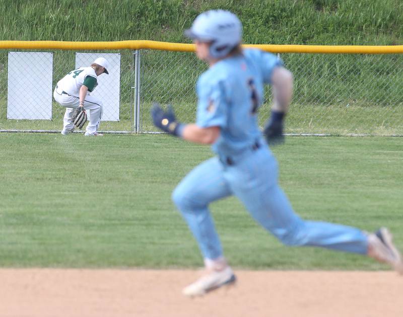 St. Bede's Geno Dinges chases down a ball in the outfield as Marquette's Jackson Higgins rounds second base on Monday, April 22, 2024 at St. Bede Academy.