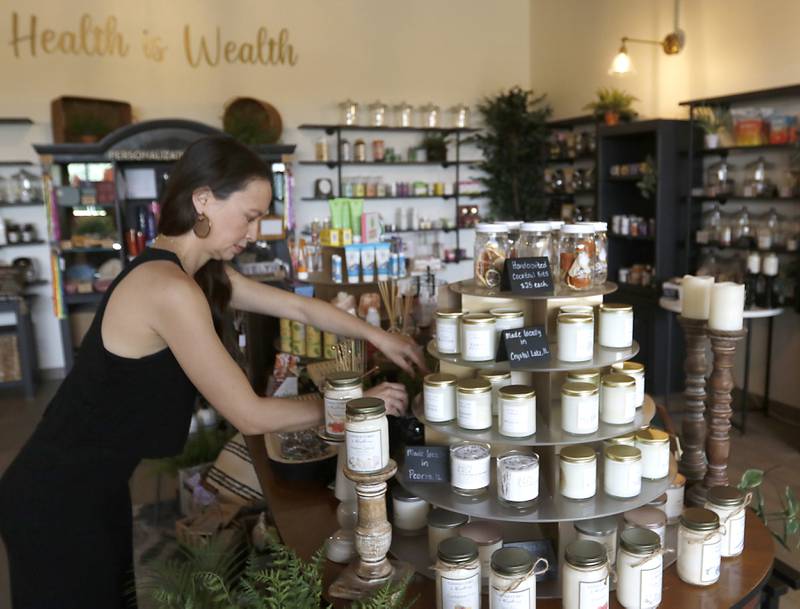 Tami Moore-Kedzie adjust items for sale inside her new business, Cary Apothecary, on June 25, 2024.