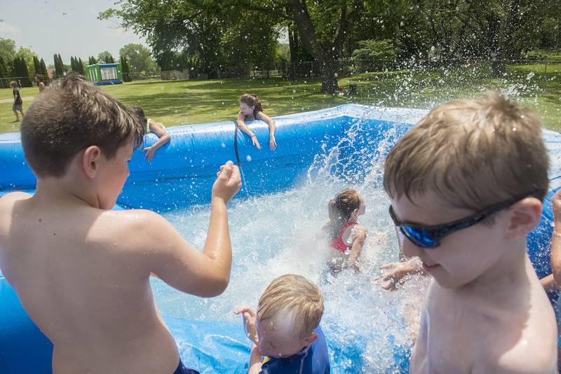 Campers get splashed Wednesday, June 15, 2022 at the end of a friends ride down the waterslide.