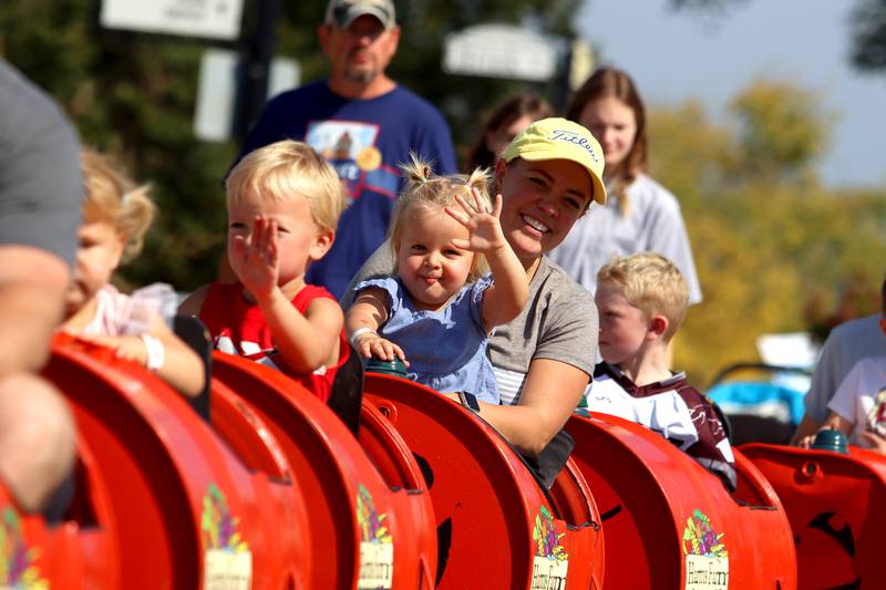 Amy Ferraro of Cary takes a spin on a pumpkin wagon with her daughter Cameron, 2, during the Johnny Appleseed Festival in Crystal Lake Saturday.