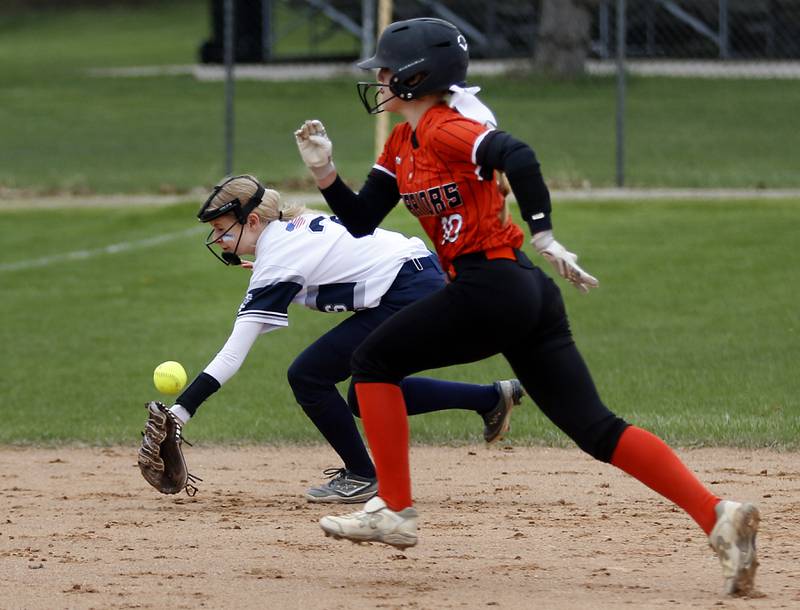 McHenry’s Tatum Kornfeind runs to third as Cary-Grove’s Aubrey Lonergan tries to field the ball during a Fox Valley Conference Softball game Monday, May 2, 2022, between Cary-Grove and McHenry at Cary-Grove High School.