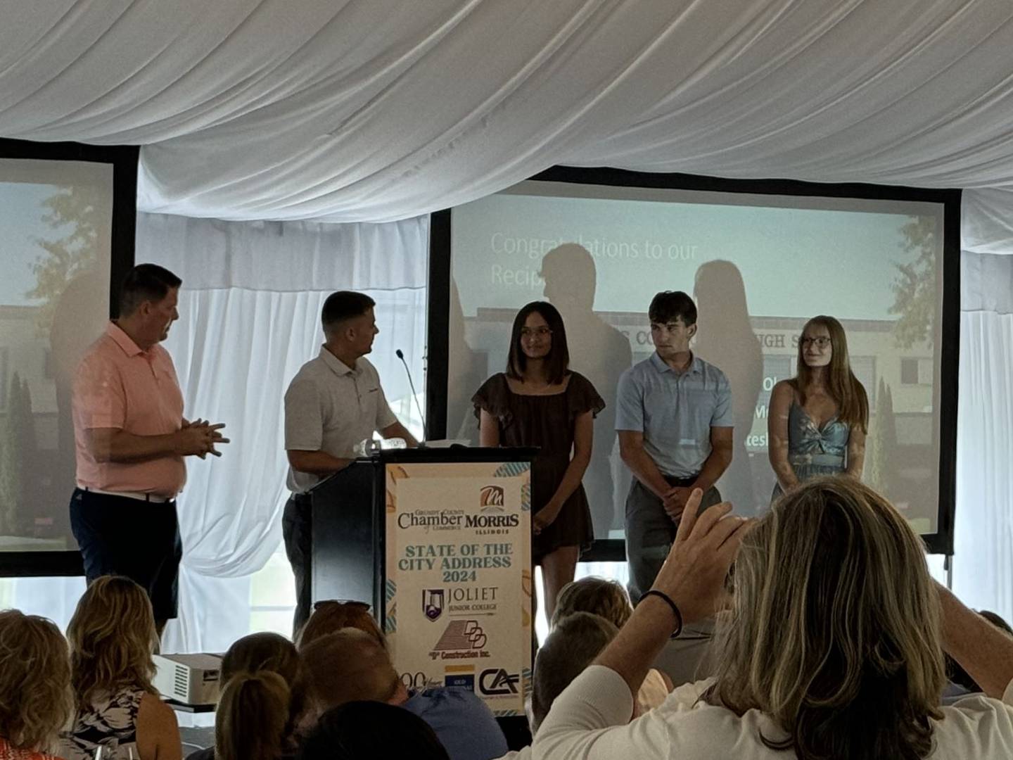 (From left) Morris Mayor Chris Brown and Edward Jones' Austin Feeney award Stephanie Olena, Sam Mateski and Miranda Muffler with scholarships.