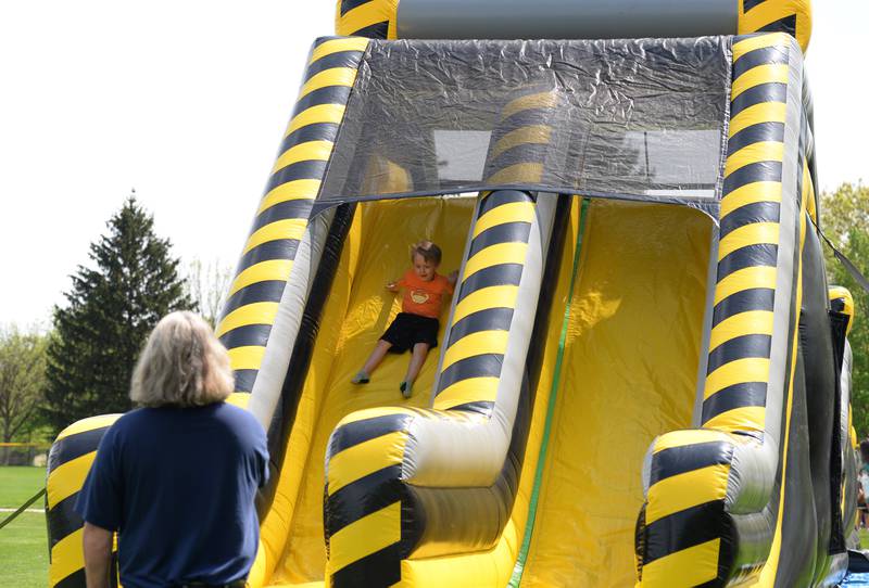 Cliff Denberg of Downers Grove watches as his grandson Cliff Denberg of Lockport slides down the obstacle course during the Downers Grove Park District's 75th anniversary party at McCollum Park Saturday, May 14, 2022.