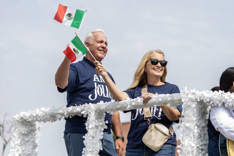 Joliet Mayor Terry D’arcy and City Manager Beth Beatty wave flags during the City of Joliet Fiestas Patrias Mexican Independence Day Parade on Sept. 13, 2025.