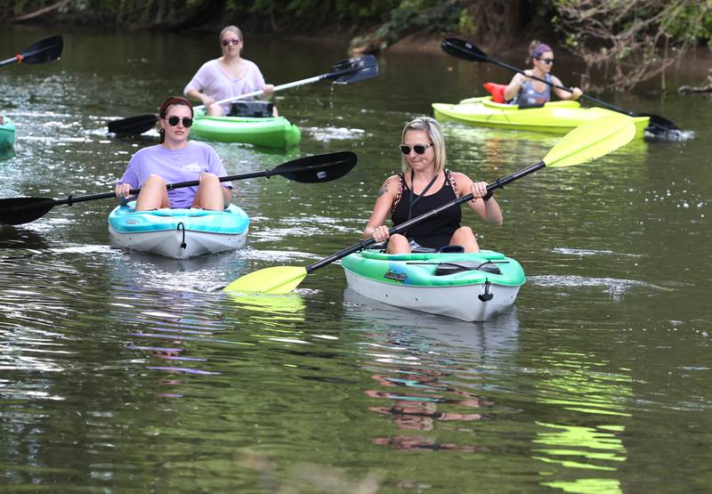 Carla Biesiadecki, (front) from Sycamore, paddles downstream with friends in the Kishwaukee River Sunday, July 31, 2022, near David Carrol Memorial Citizens Park in Genoa.