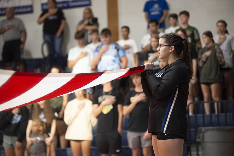 Newman’s Leah Kalina holds one corner of a the flag during a special ceremony before their volleyball game Thursday, Sept. 15, 2022 against Princeton.