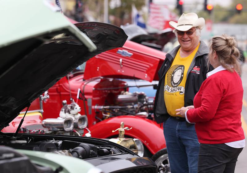 Mike Tritle, from DeKalb talks to Jeanne Baxter, assistant director of the Center for Student Assistance at Northern Illinois University about his 2015 Mustang Ecoboost at the car show during the NIU Huskie Homecoming Block Party Thursday, Oct. 12, 2023, in downtown DeKalb.