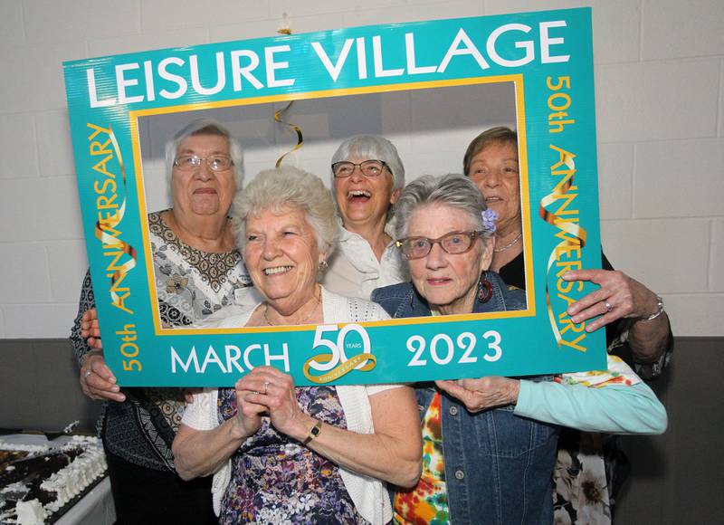 Diane Crockett and Betty Flint (in front) get their photo taken with Karen Morris, Chris Swientek and Darlene Peterson (in back) during the Senior Prom to celebrate the 50th Anniversary of Leisure Village in Fox Lake.