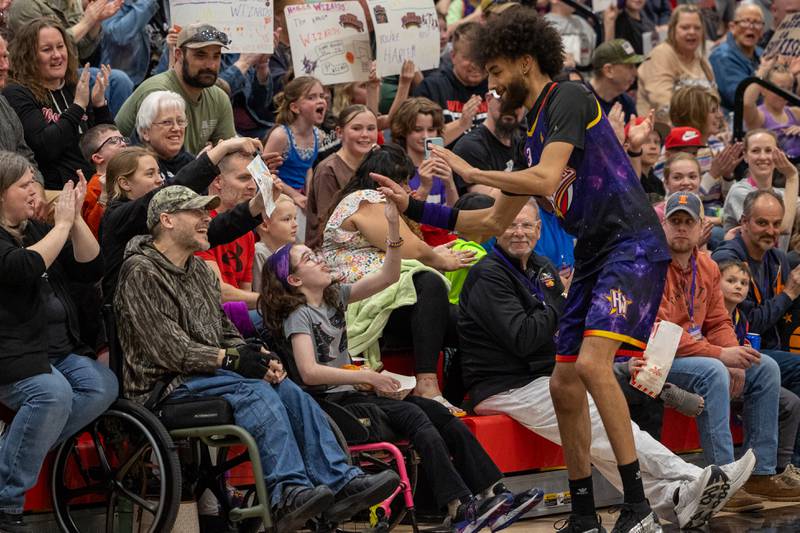Tyler “Sky-Rise” Cronk (35) of the Harlem Wizards high-fives Addy Renken on Wednesday, April 16, 2025 at Woodland High School in Streator.