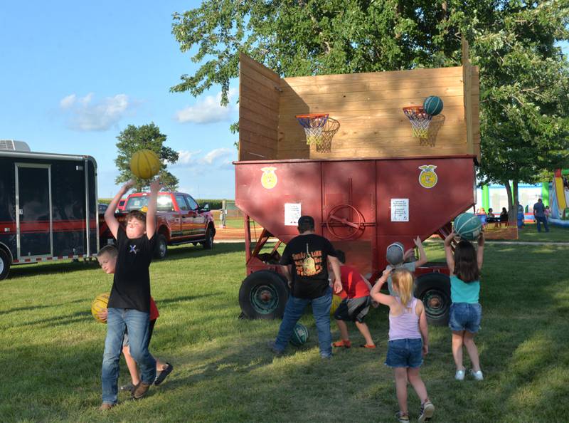 KIds attempt a variety of basketball shots at the homemade FFA attraction at the Lee County Fair on Saturday, July 29, 2023.