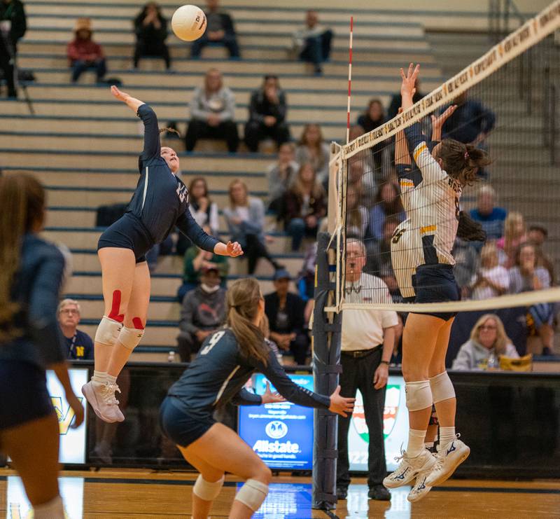 Oswego East's Megan Maier (15) goes up for a kill against Neuqua Valley during the Neuqua Valley 4A regional final volleyball match at Neuqua Valley High School in Naperville on Thursday, Oct 27, 2022.