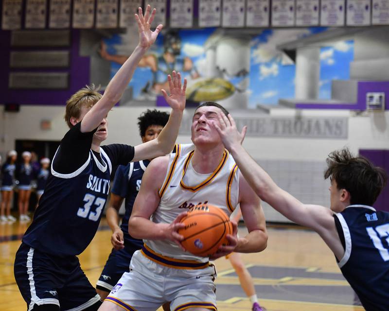 Downers Grove North’s Colin Doyle is fouled on his way to the basket during a game against Downers Grove South on December 20, 2025 at Downers Grove North High School in Downers Grove.