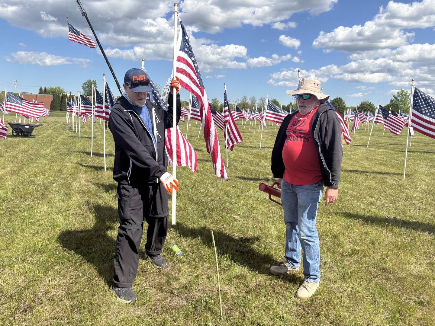Ken Berger, left, and Matt Charlier hold a flag at the Field of the Fallen in Cary May 23, 2025.