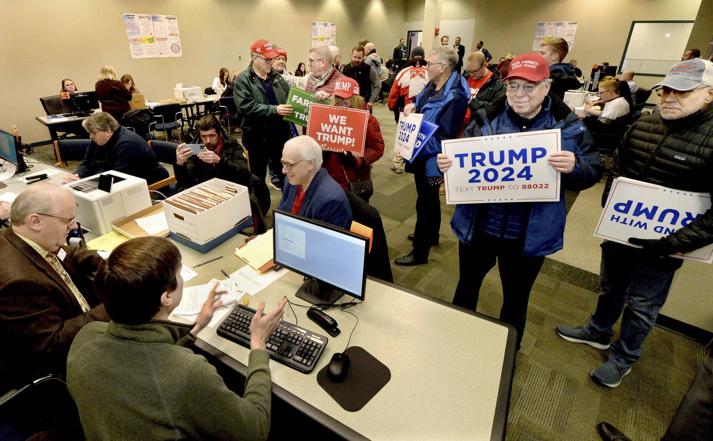Supporters of Republican presidential candidate Donald Trump submit nomination papers with state election authorities, Thursday, Jan. 4, 2024, at the State Board of Elections in Springfield, Ill.