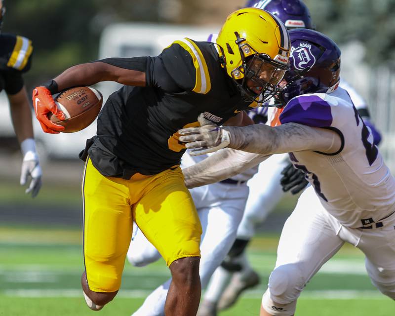 St Laurence's Aaron Ball (6) runs through the tackle attempt by Dixon's Eli Davidson (27) during Class 4A second round playoff football playoff game between Dixon at St Laurence.  Nov 4, 2023.