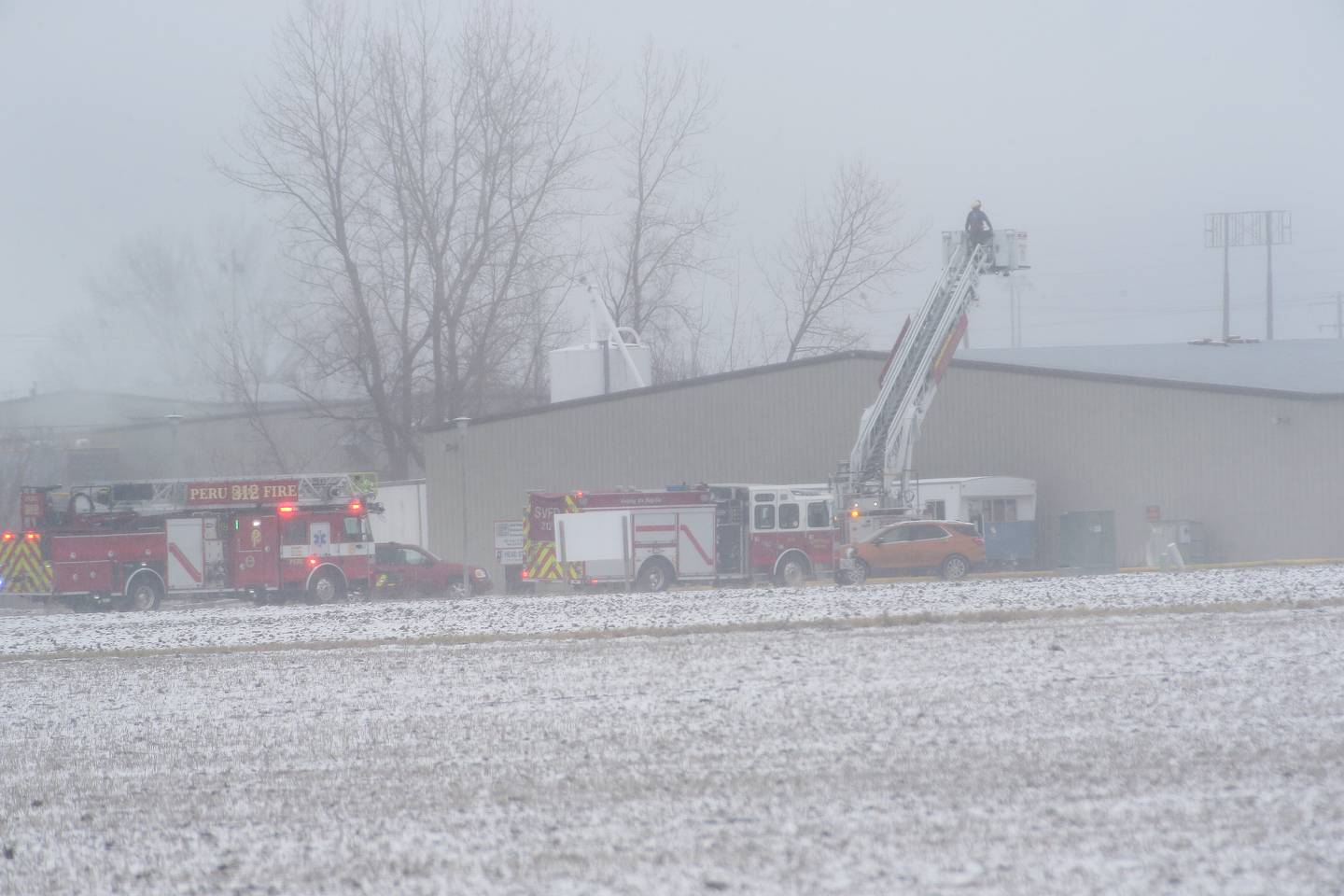 Peru firefighters work the scene of a structure fire at TDJ Group warehouse on Friday, Feb. 16, 2024 north of Peru. The fire began shortly after 11a.m. Fire departments from across the Illinois Valley are responding to the scene.