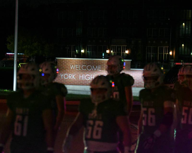 York High School football players walk from the school to the football stadium on Friday Oct. 17, 2025, while taking on Glenbard West held at York High School.