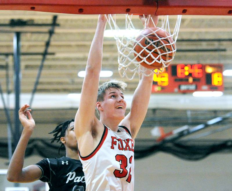 Yorkville's Jason Jakstys (32) dunks the ball in front of Oswego East defender Mason Lockett, IV during a varsity basketball game at Yorkville High School on Friday, Feb. 9, 2024.