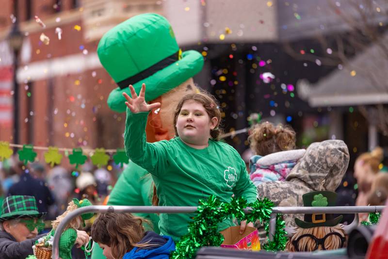 A parade participant tosses candy from a float as confetti fills the sky behind her during the St. Patrick's Day Parade on March 7, 2026 in Utica.