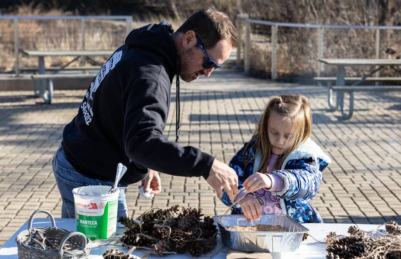 Erich Hoffmann, left, helps his daughter Emery Hoffmann, 7, with a craft during the Welcome Winter Celebration at the Lost Valley Visitor Center in Ringwood on Saturday, Dec. 28, 2024. The celebration included traditional indigenous music, dance and traditional activities for attendees.