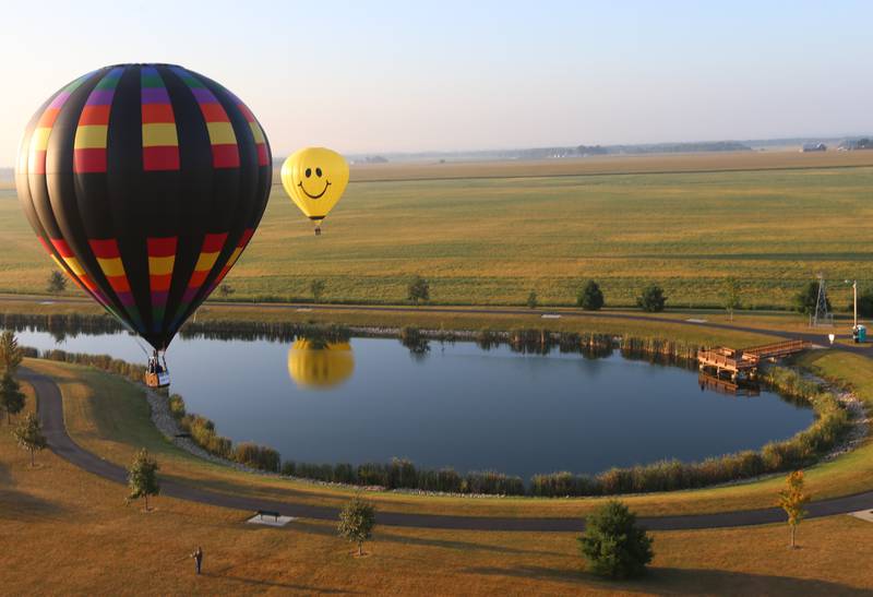 Hot air balloons fly over the lake at Zearing Park during the 52nd annual Homestead Festival on Saturday, Sept. 9 2023 in Princeton.