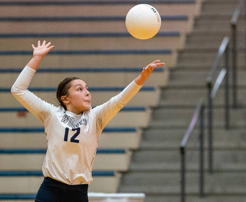 Oswego East's Chloe Austin (12) serves the ball against Neuqua Valley during the Neuqua Valley 4A regional final volleyball match at Neuqua Valley High School in Naperville on Thursday, Oct 27, 2022.